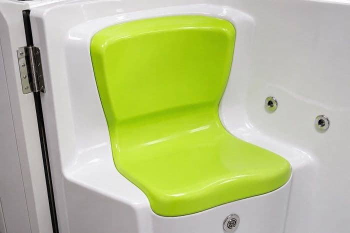A modern walk in bath shower with a smooth contoured acrylic seat, shown in a bright accessible bathroom